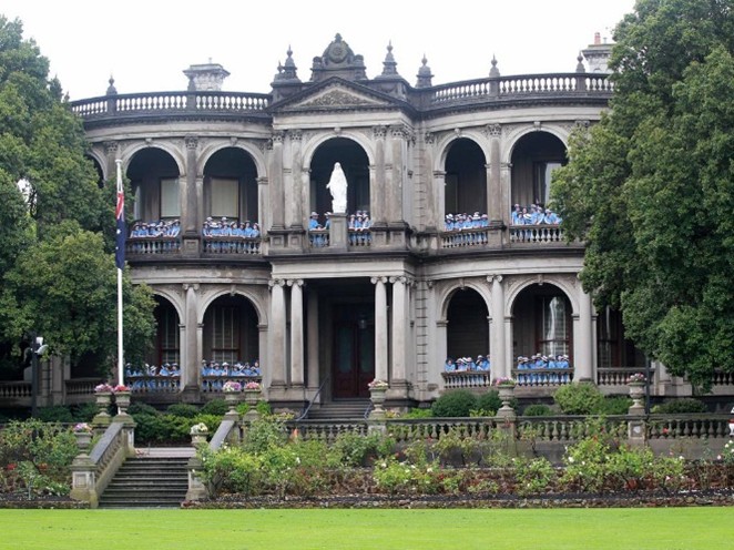 A group of girls stand in front of Mandeville Hall
