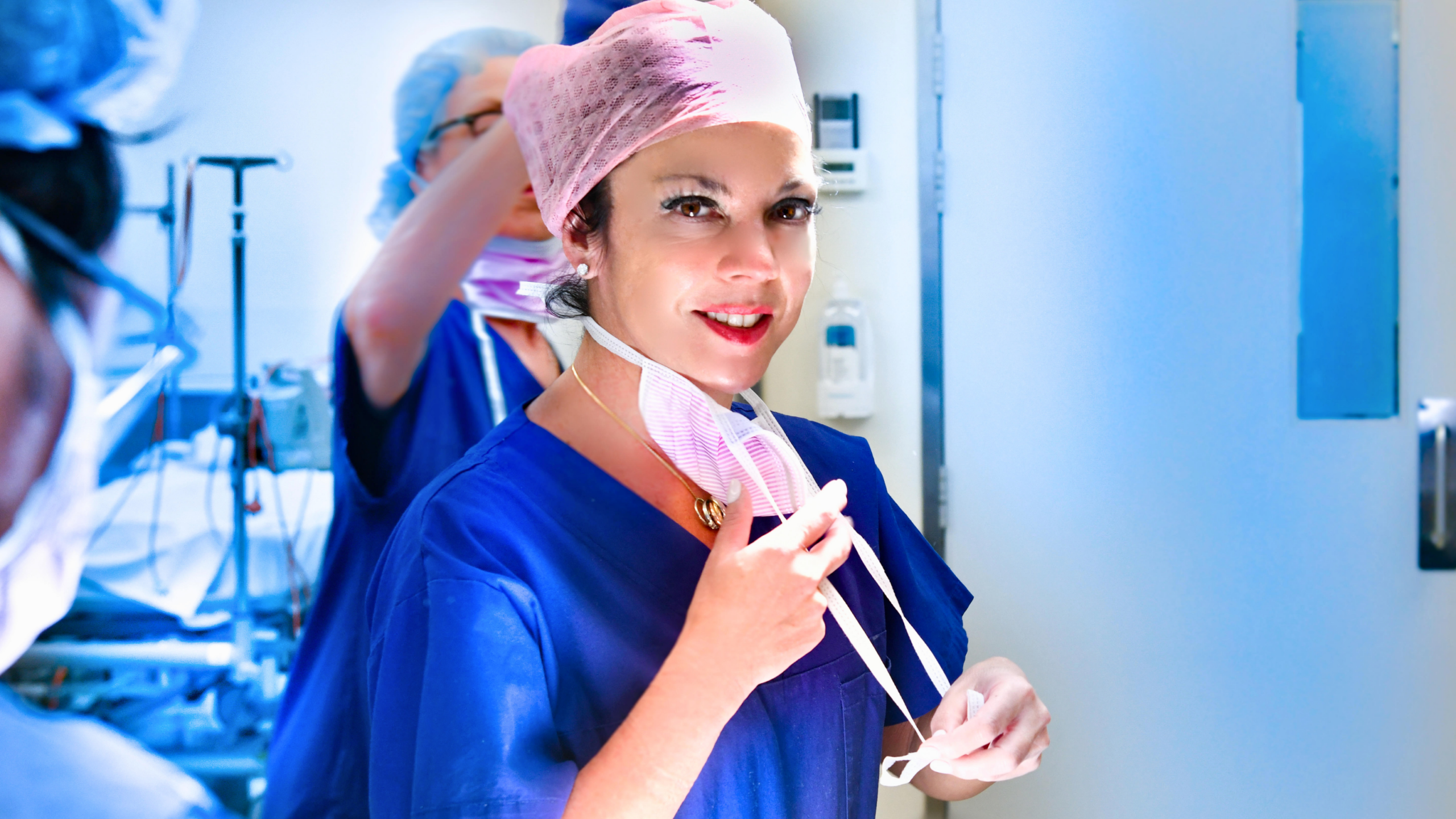 Dr Nicole Yap is dressed in surgical scrubs and smiling at the camera